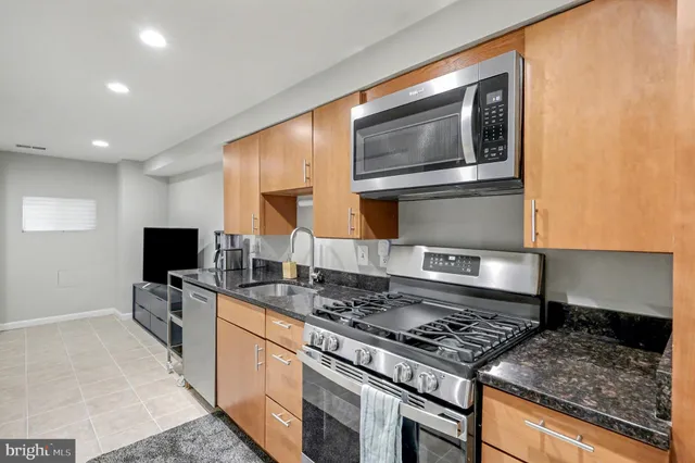 a kitchen with stainless steel appliances granite countertop a stove and a sink