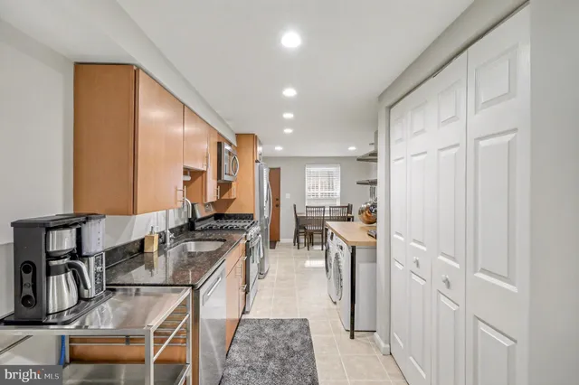 a kitchen with stainless steel appliances granite countertop a refrigerator and a stove