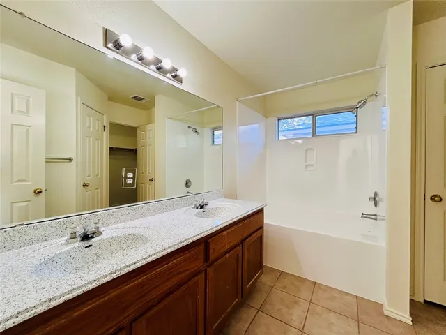 a bathroom with a granite countertop sink mirror and bathtub