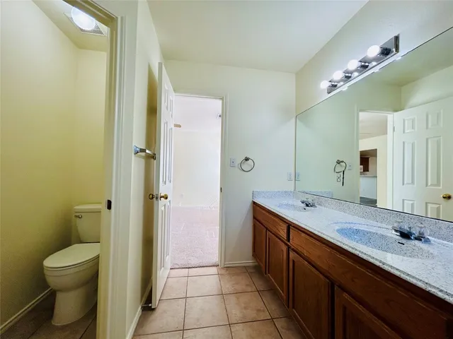 a spacious bathroom with a granite countertop sink mirror and toilet