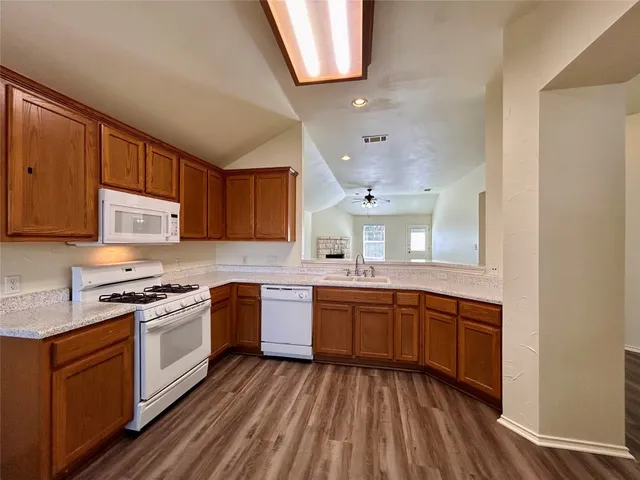 a kitchen with stainless steel appliances granite countertop wooden cabinets sink and stove top oven