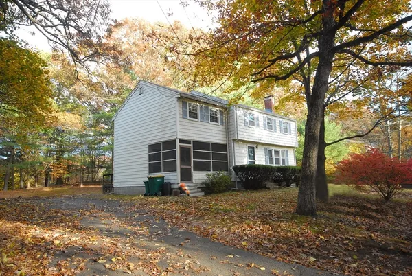 a view of a house with backyard and trees