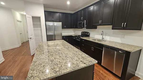 a kitchen with stainless steel appliances wooden cabinets and a stove top oven