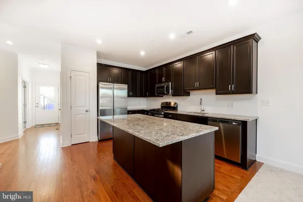 a kitchen with stainless steel appliances granite countertop a stove a refrigerator and a sink