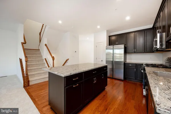 a large kitchen with a stove a sink and a refrigerator