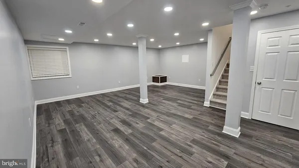 a view of empty room with wooden floor