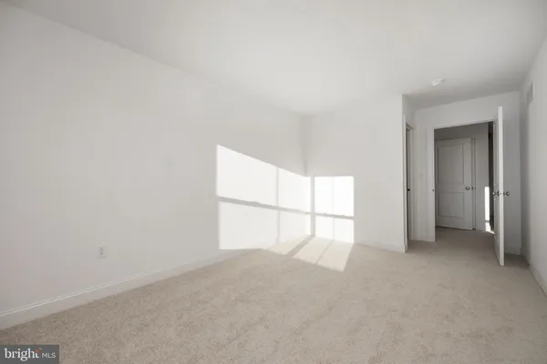 an empty room with a window and ceiling fan
