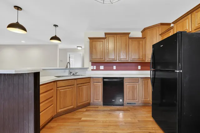 a kitchen with stainless steel appliances granite countertop a refrigerator a sink and dishwasher