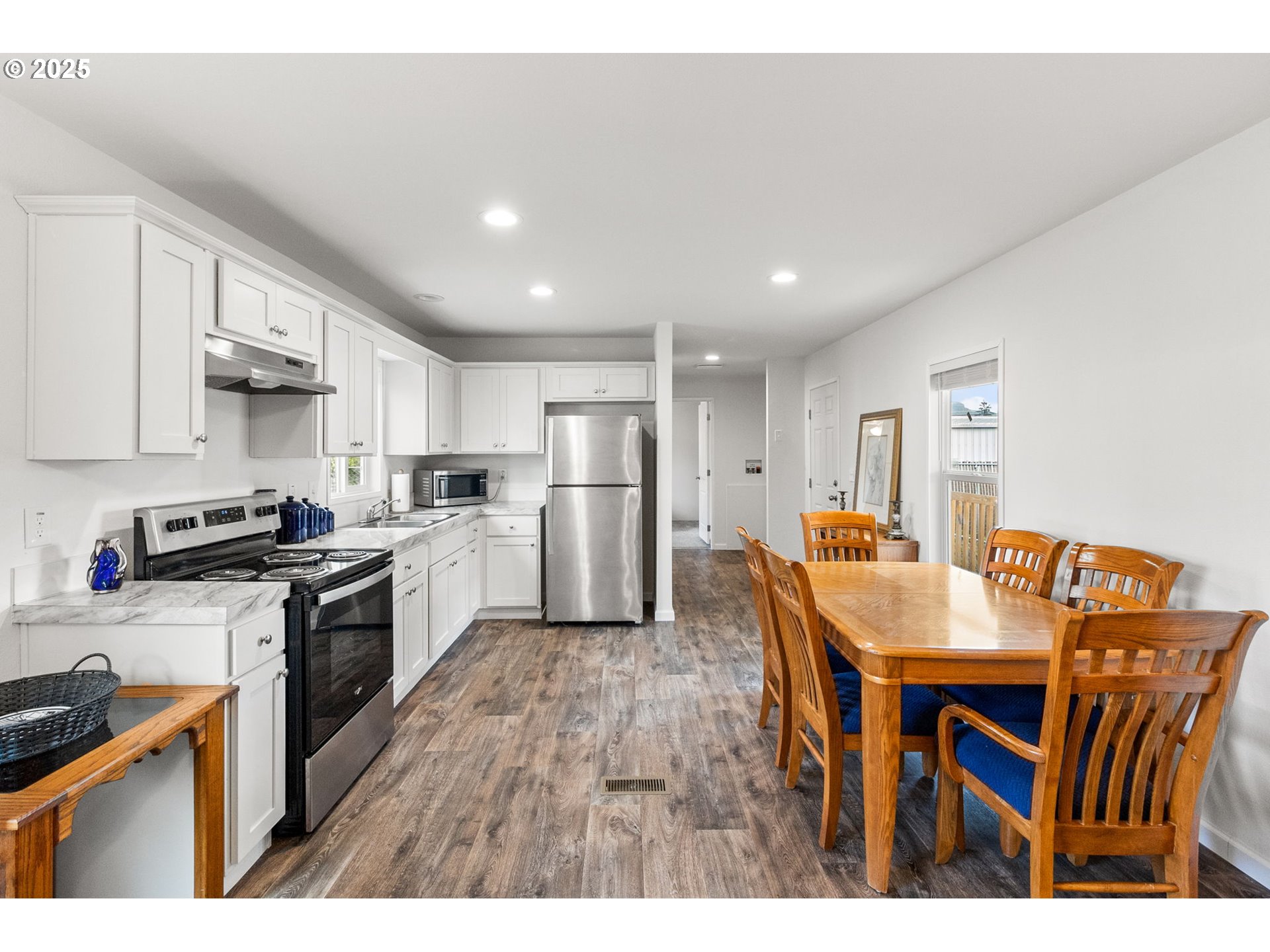 5335 Main Street, Unit 187 Springfield, OR 97478 - Photo 13 of 39 a kitchen with stainless steel appliances granite countertop a table chairs sink and cabinets