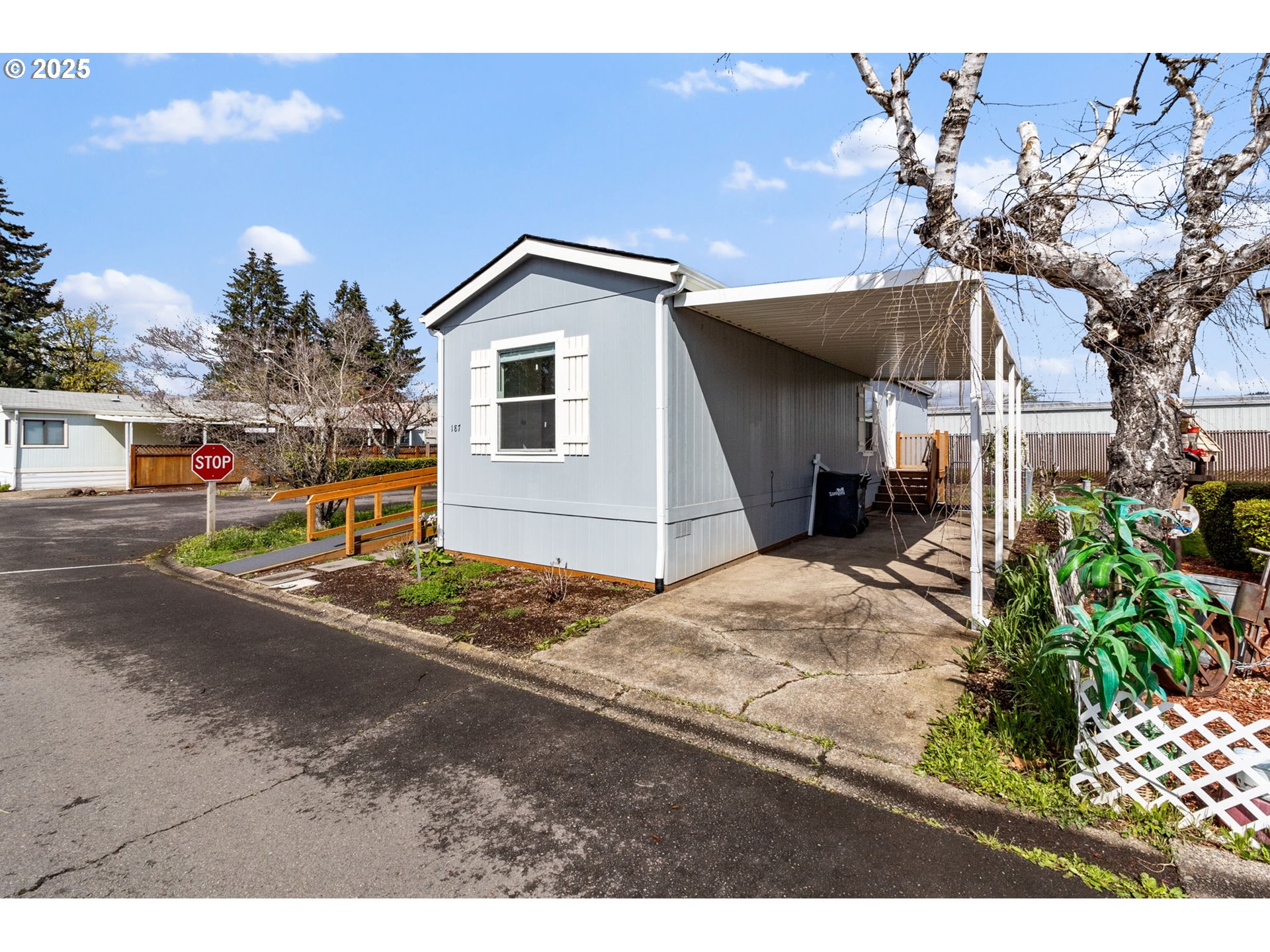 5335 Main Street, Unit 187 Springfield, OR 97478 - Photo 2 of 39 a view of a white house with a yard and potted plants