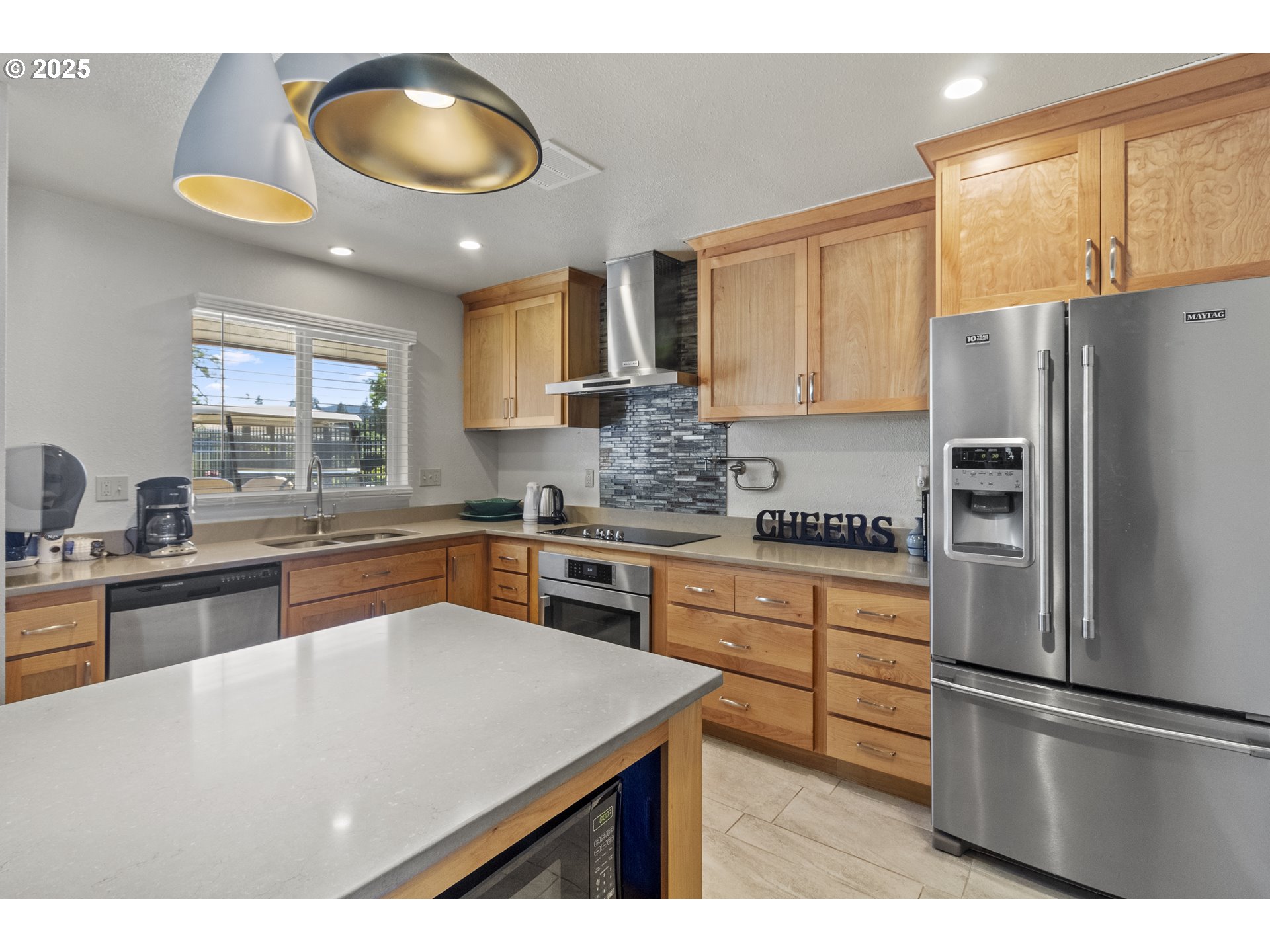 5335 Main Street, Unit 187 Springfield, OR 97478 - Photo 32 of 39 a kitchen with stainless steel appliances granite countertop a sink a stove a refrigerator a center island and a window