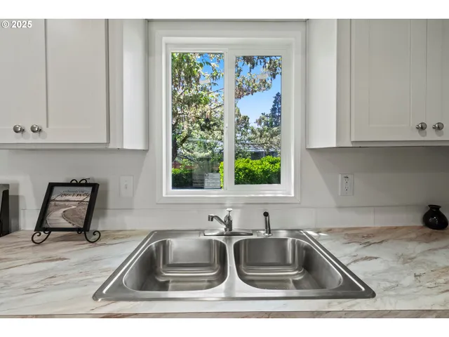 a kitchen with granite countertop a sink a stove and cabinets