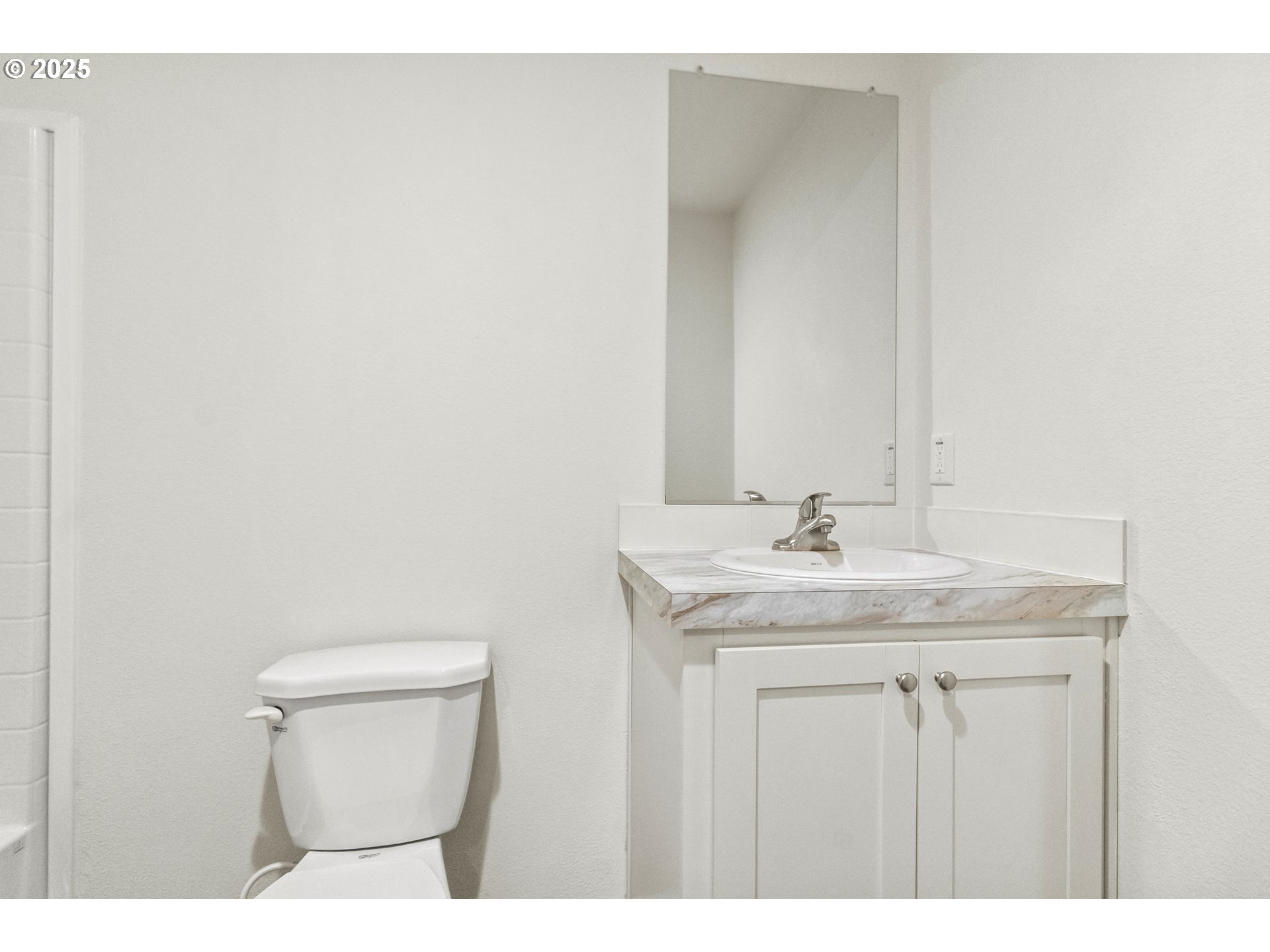 5335 Main Street, Unit 187 Springfield, OR 97478 - Photo 10 of 39 a bathroom with a granite countertop sink a toilet and a mirror
