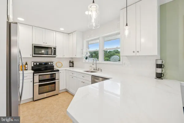 a kitchen with granite countertop a stove a sink and a microwave
