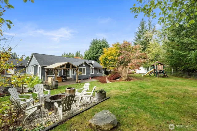 a view of a house with a big yard potted plants and large tree
