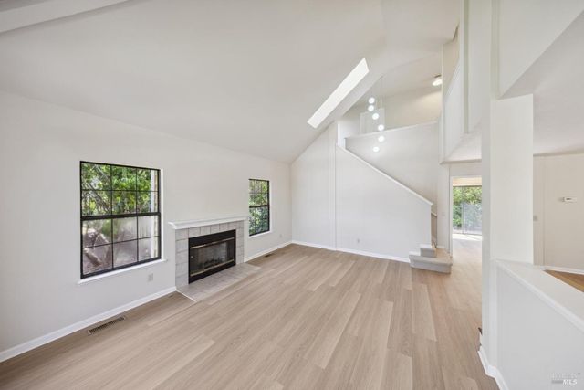 an empty room with windows and fireplace