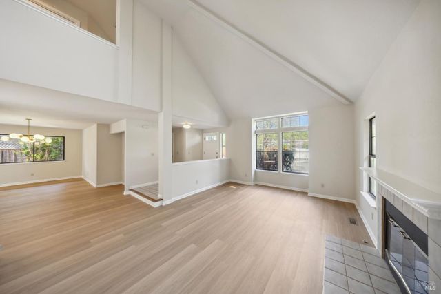 an empty room with windows fireplace and windows