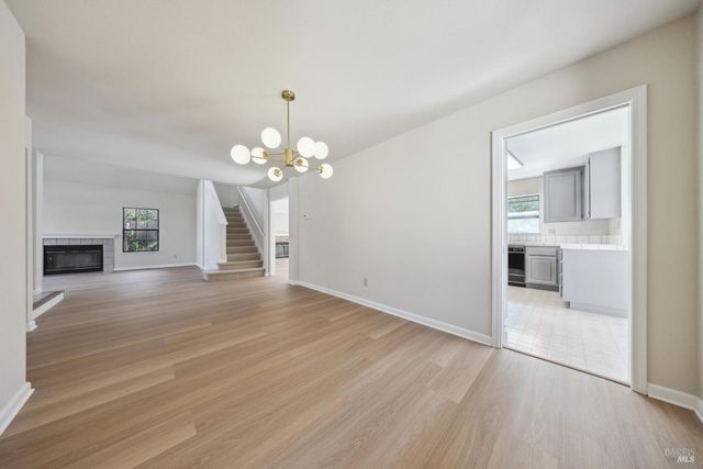 a view of a livingroom with wooden floor and a fireplace