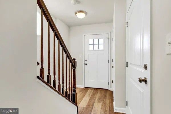 a view of a hallway with wooden floor and staircase