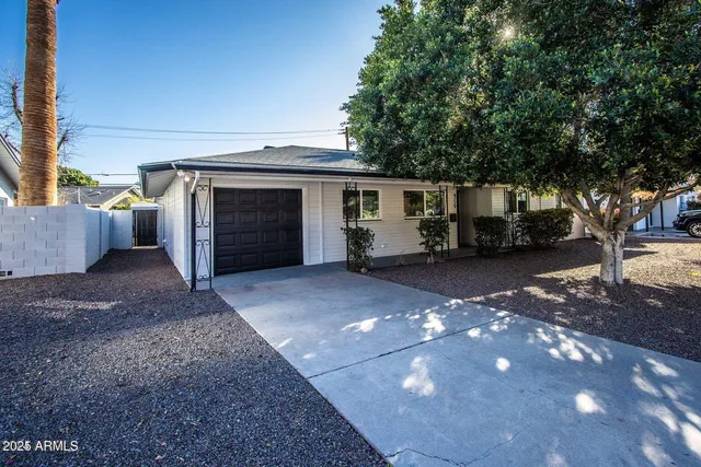 a view of a parking space with garage and a barbeque