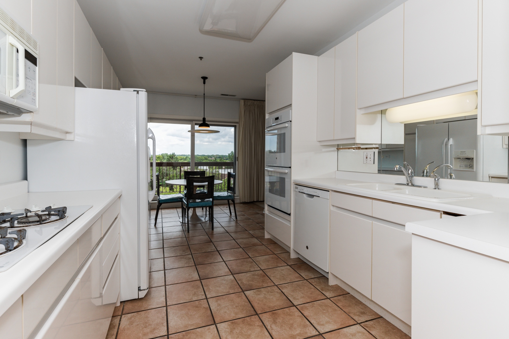 211 Rivershire Lane, Unit 501 Lincolnshire, IL 60069 - Photo 5 of 17 a kitchen with a sink dining table and chairs