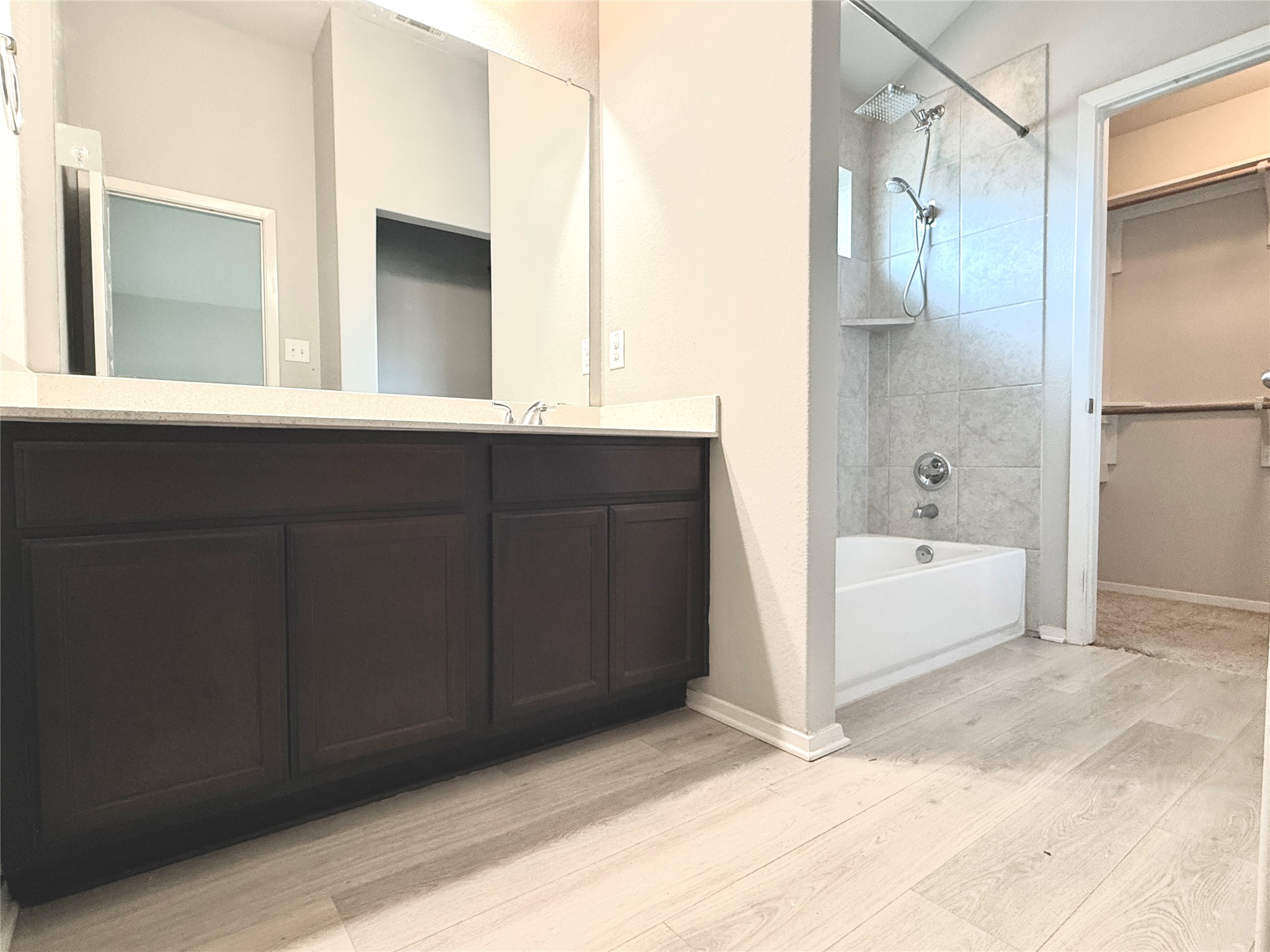 5629 Corso Court Austin, TX 78747 - Photo 15 of 23 Bathroom featuring shower / bath combination, light wood-type flooring, vanity, and a spacious closet