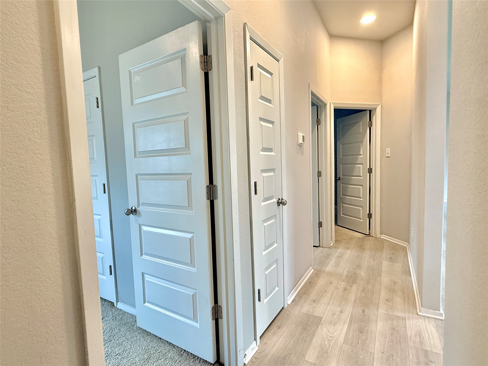 5629 Corso Court Austin, TX 78747 - Photo 19 of 23 Hall with a textured wall and light wood-style flooring