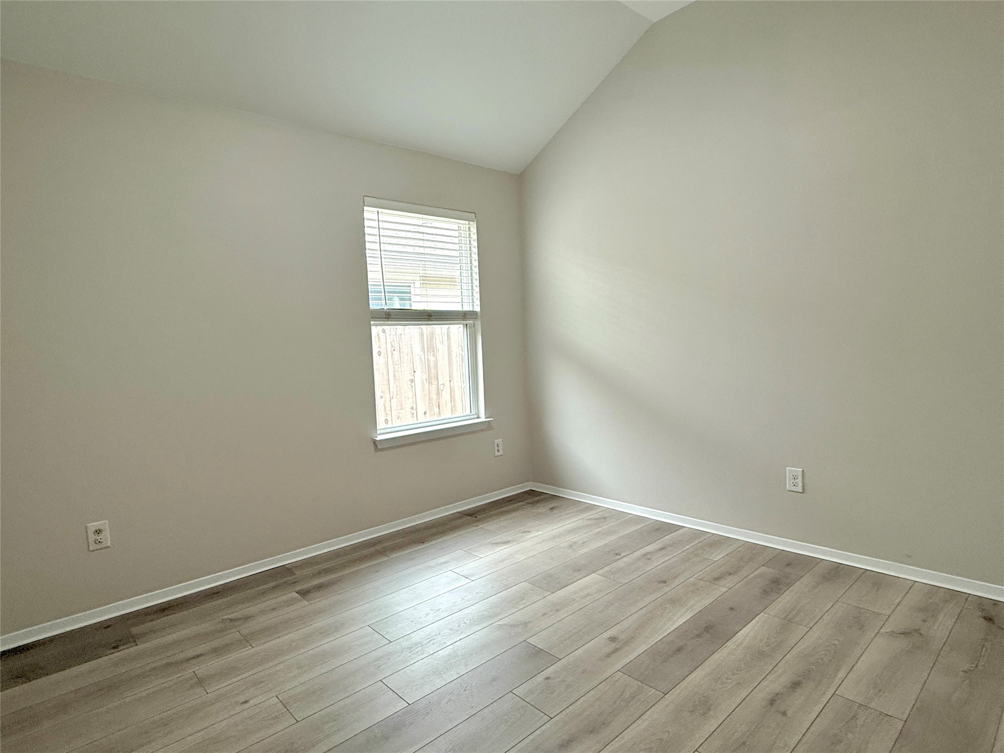 5629 Corso Court Austin, TX 78747 - Photo 22 of 23 Empty room with lofted ceiling and light wood-style flooring