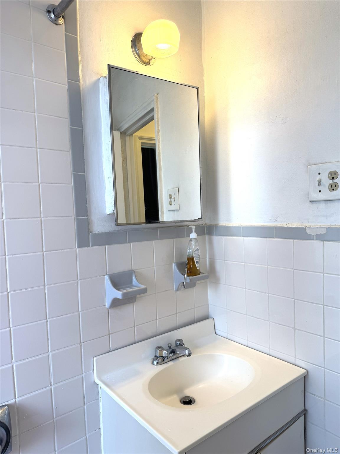 141-24 78th Road, Unit 3A Queens, NY 11367 - Photo 12 of 18 a bathroom with a sink and a mirror