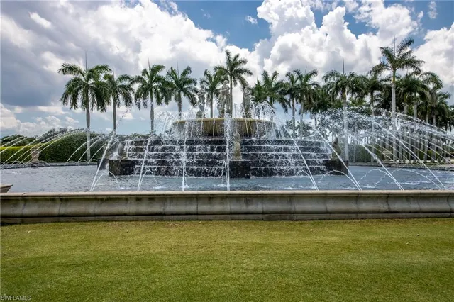 a view of a swimming pool with a yard and palm trees
