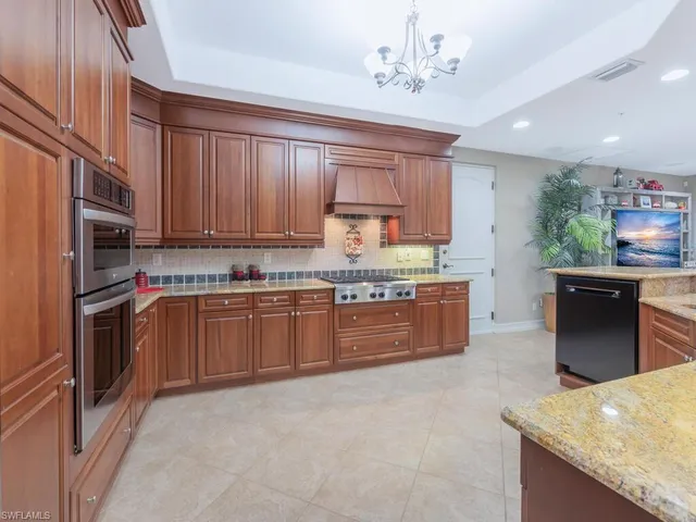 a kitchen with stainless steel appliances granite countertop a refrigerator a stove top oven a sink and dishwasher