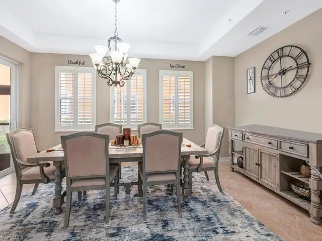 a view of a dining room with furniture a chandelier and a window