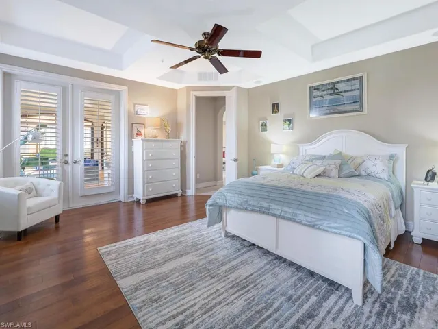 a bedroom with a large bed and a wooden floor