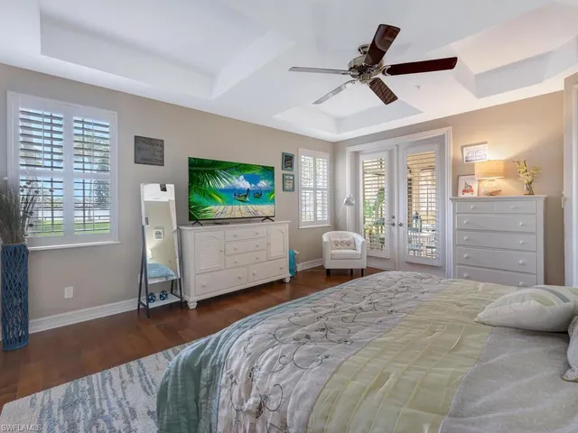 a bedroom with a bed a flat screen tv and a large window