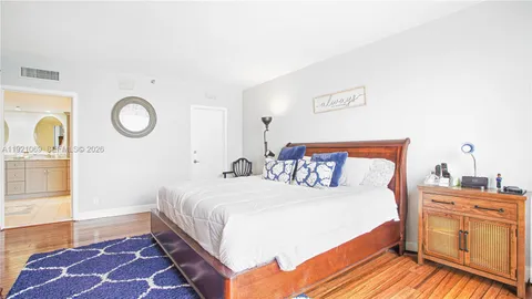 a bedroom with a bed and a lamp on dresser