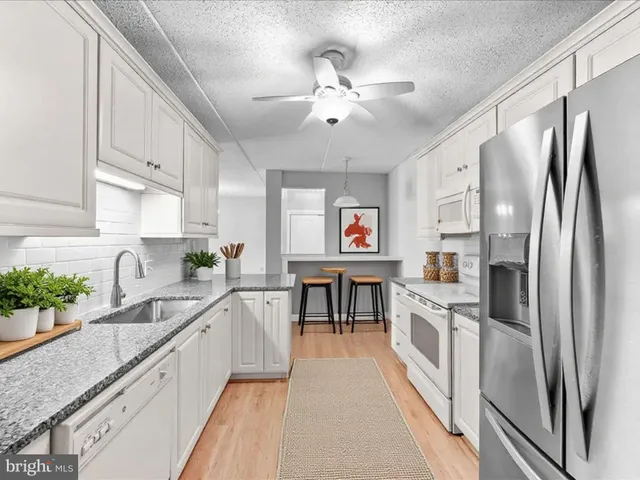 a kitchen with stainless steel appliances granite countertop a refrigerator and a sink
