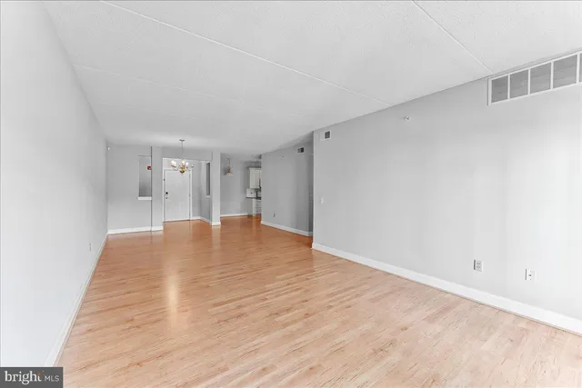 a view of empty room with wooden floor