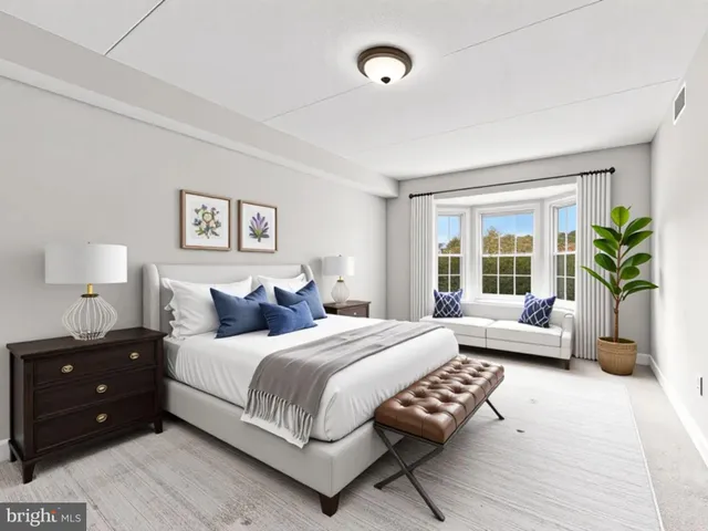 a bedroom with a bed a couch and a potted plant on the dresser