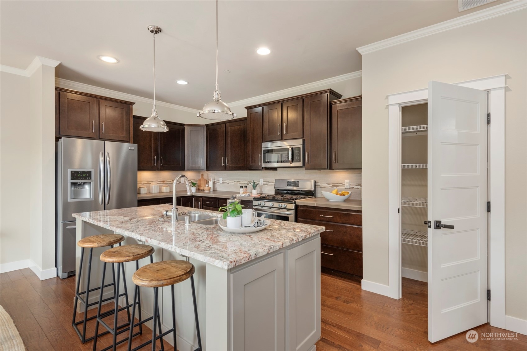 2406 196th Place Southeast Bothell, WA 98012 - Photo 12 of 30 a kitchen with stainless steel appliances granite countertop a kitchen island a stove a refrigerator a sink a table and chairs
