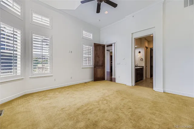 an empty room with windows and ceiling fan