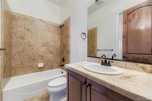 a bathroom with a granite countertop sink toilet and shower