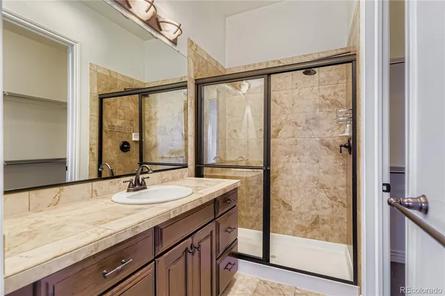 a bathroom with a granite countertop sink and a mirror