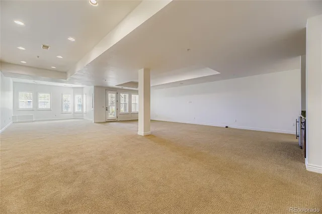 a view of an empty room with a window and chandelier