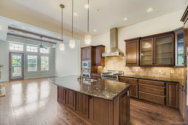 a kitchen with stainless steel appliances granite countertop a sink a oven and wooden cabinets