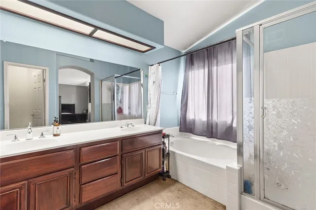 a spacious bathroom with a double vanity sink mirror and bathtub
