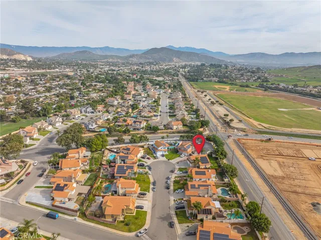an aerial view of residential houses with outdoor space and trees