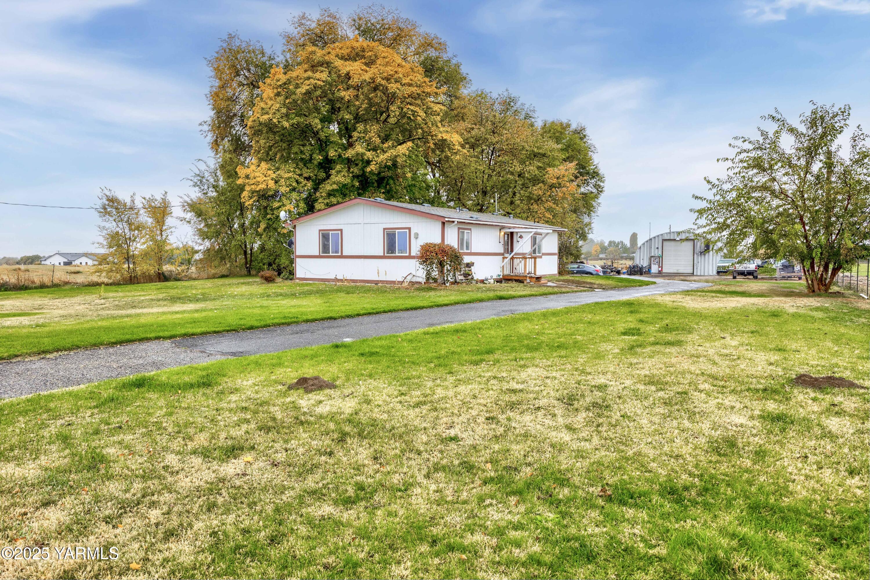a view of a house with a big yard and a large tree