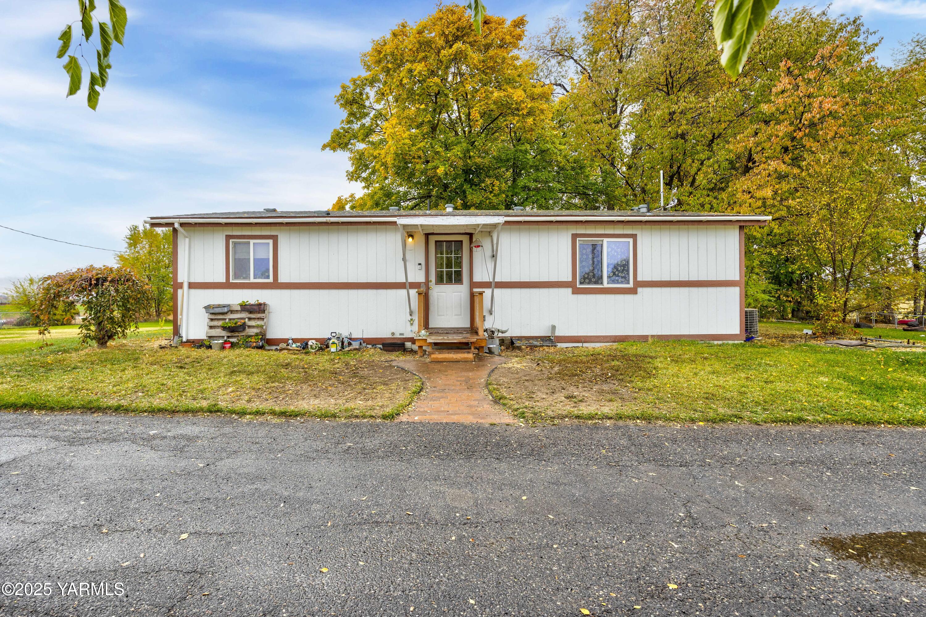 7702 North Griffin Road Grandview, WA 98930 - Photo 12 of 29 a view of a house with a yard and large trees