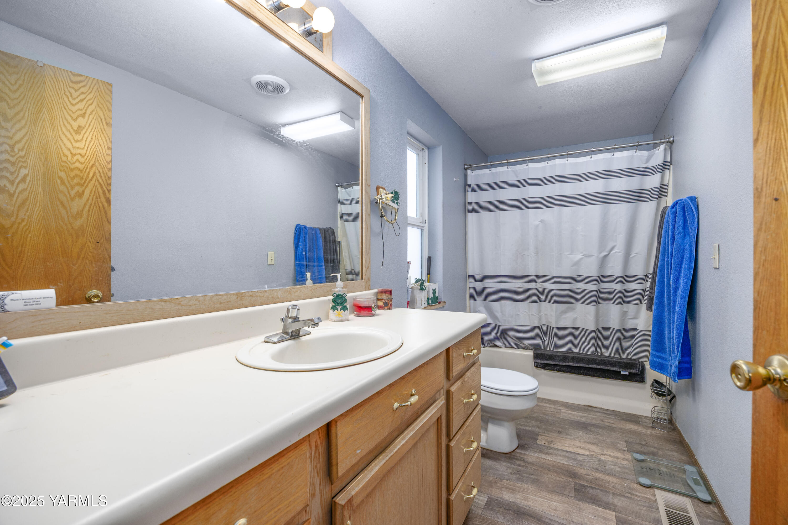 7702 North Griffin Road Grandview, WA 98930 - Photo 18 of 29 a bathroom with a sink a toilet and shower curtain