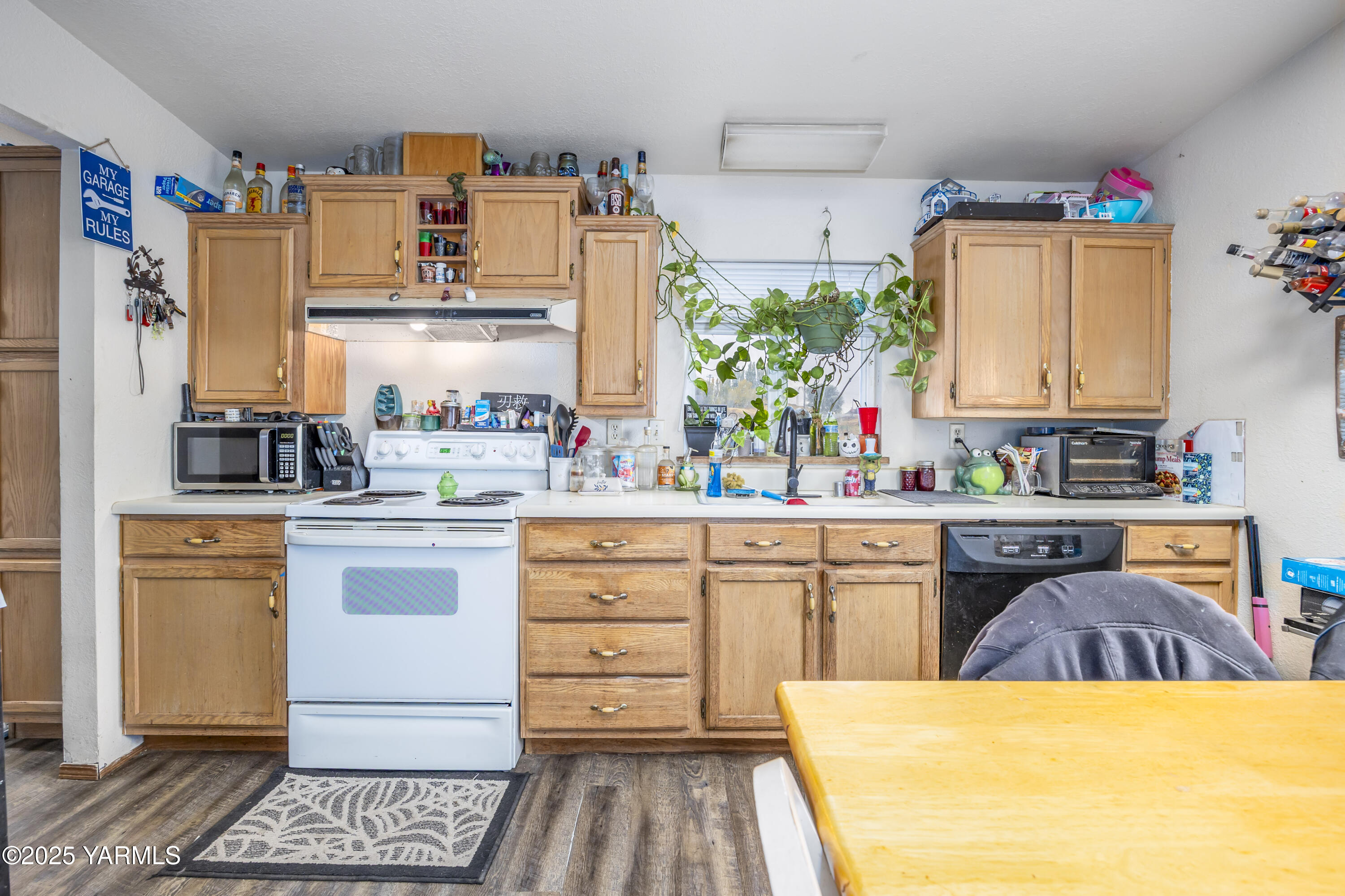 7702 North Griffin Road Grandview, WA 98930 - Photo 9 of 29 a kitchen with a refrigerator and white cabinets